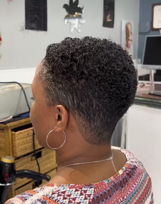 Coupe courte femme bouclée vue de dos réalisée chez Ciseaux d'Or
